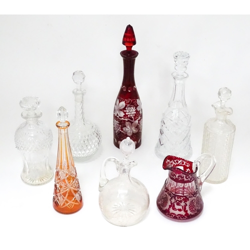 253 - A quantity of assorted cut glass and lead crystal decanters, to include a Bohemian red glass example... 