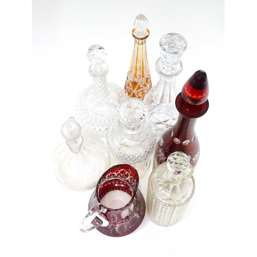 253 - A quantity of assorted cut glass and lead crystal decanters, to include a Bohemian red glass example... 