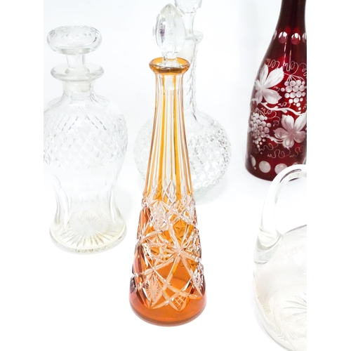 253 - A quantity of assorted cut glass and lead crystal decanters, to include a Bohemian red glass example... 