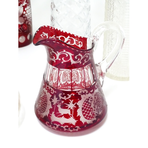 253 - A quantity of assorted cut glass and lead crystal decanters, to include a Bohemian red glass example... 