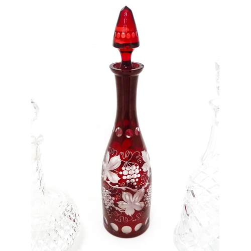 253 - A quantity of assorted cut glass and lead crystal decanters, to include a Bohemian red glass example... 