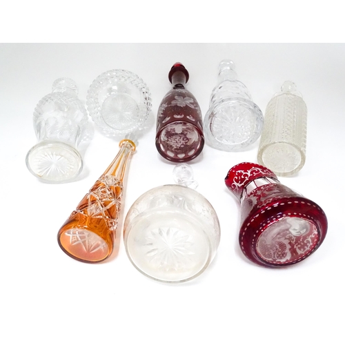 253 - A quantity of assorted cut glass and lead crystal decanters, to include a Bohemian red glass example... 