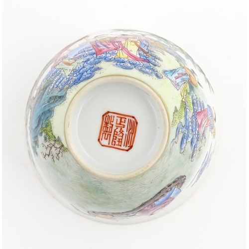 29 - A Chinese famille rose tea bowl decorated with figures in a river landscape. Character marks under. ... 