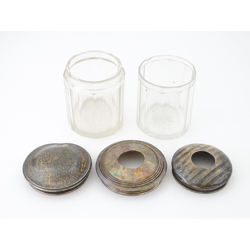 608 - Two glass dressing table jars with silver tops, one a hair tidy. Together with another hair tidy sil... 