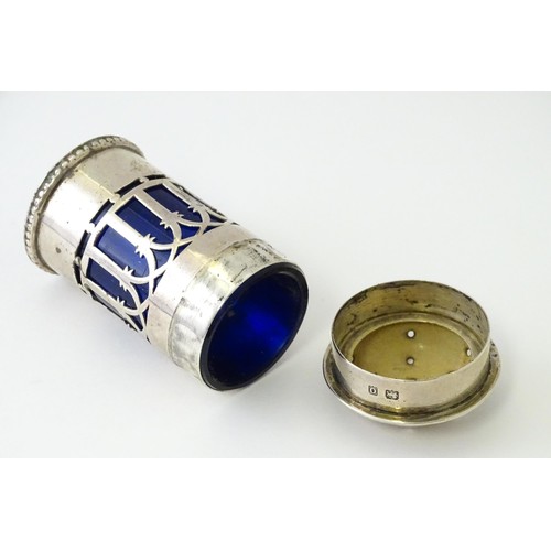 611 - A silver pepper with blue pierced decoration and glass liner, hallmarked Birmingham 1913, maker Henr... 