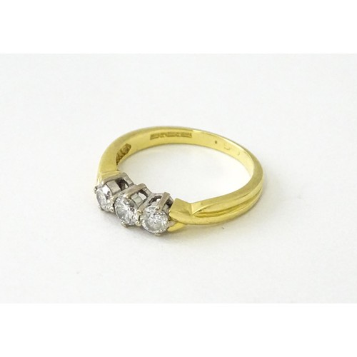 862 - An 18ct gold ring set with a trio of diamonds. Ring size approx. K 1/2