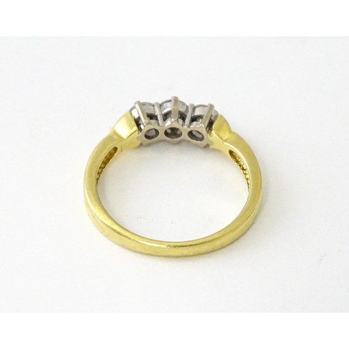 862 - An 18ct gold ring set with a trio of diamonds. Ring size approx. K 1/2