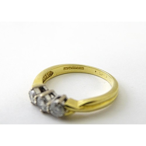 862 - An 18ct gold ring set with a trio of diamonds. Ring size approx. K 1/2