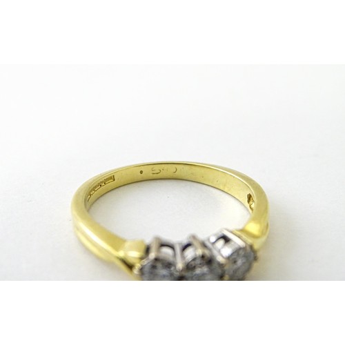 862 - An 18ct gold ring set with a trio of diamonds. Ring size approx. K 1/2