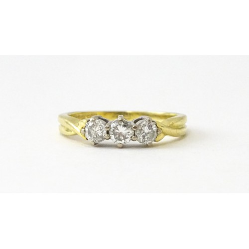 862 - An 18ct gold ring set with a trio of diamonds. Ring size approx. K 1/2