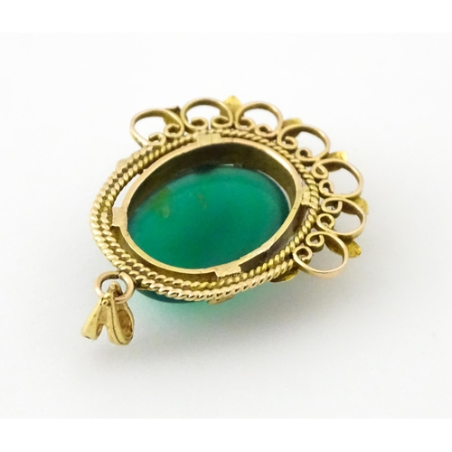 964 - A yellow metal pendant set with central green cabochon. Approx. 1 1/4