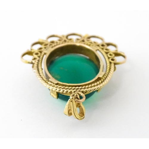 964 - A yellow metal pendant set with central green cabochon. Approx. 1 1/4