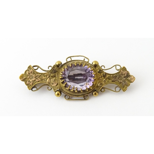 965 - A yellow metal brooch set with central amethyst. Approx. 1 3/4