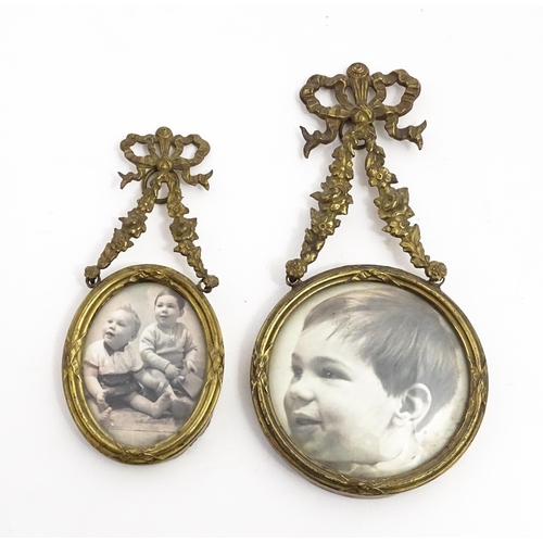 1419 - Two small early 20thC brass frames, one of circular form, the other oval, both with floral swag deco... 