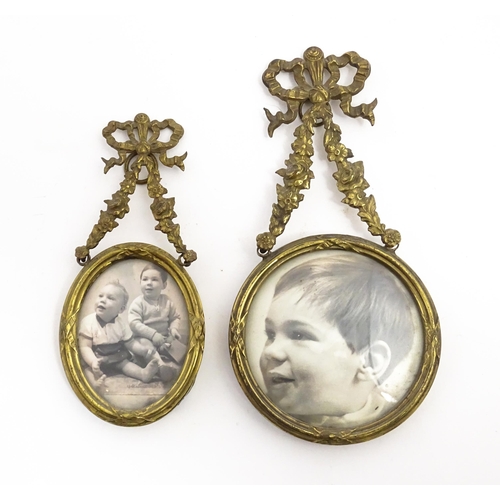 1419 - Two small early 20thC brass frames, one of circular form, the other oval, both with floral swag deco... 