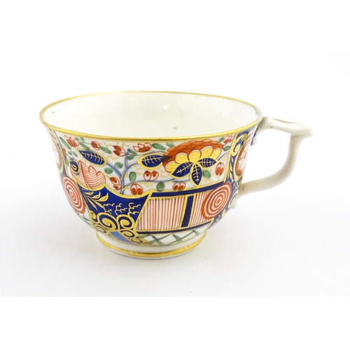 100 - A Derby tea cup and saucer decorated in the Imari palette with flowers, foliage and roundel detail. ... 