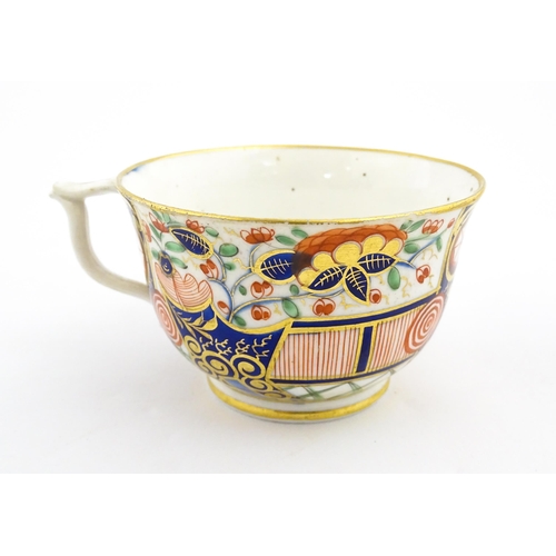 100 - A Derby tea cup and saucer decorated in the Imari palette with flowers, foliage and roundel detail. ... 