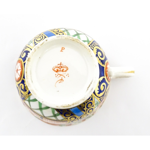 100 - A Derby tea cup and saucer decorated in the Imari palette with flowers, foliage and roundel detail. ... 