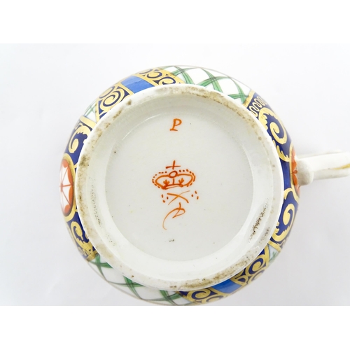 100 - A Derby tea cup and saucer decorated in the Imari palette with flowers, foliage and roundel detail. ... 