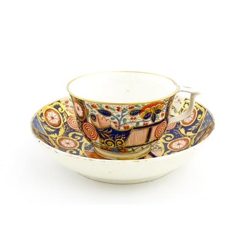 100 - A Derby tea cup and saucer decorated in the Imari palette with flowers, foliage and roundel detail. ... 