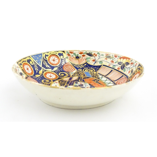 100 - A Derby tea cup and saucer decorated in the Imari palette with flowers, foliage and roundel detail. ... 