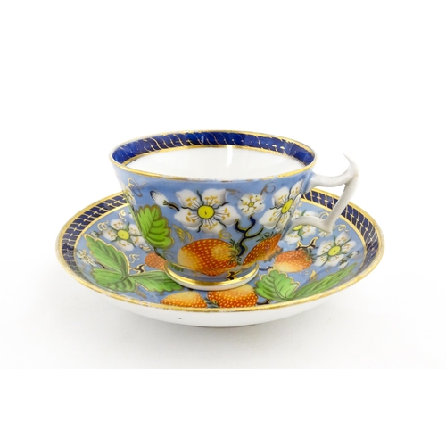 106 - A 19thC tea cup and saucer decorated with strawberry and flower detail. Cup approx. 2 1/4