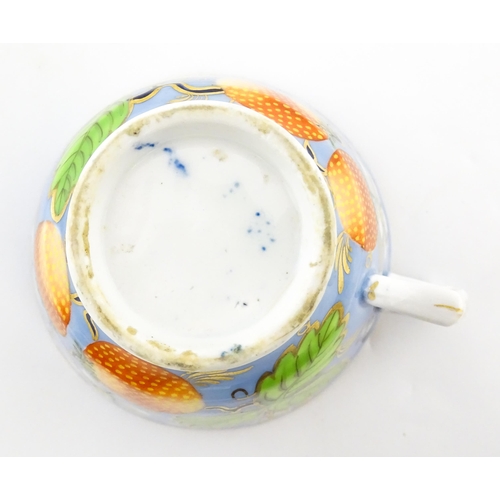 106 - A 19thC tea cup and saucer decorated with strawberry and flower detail. Cup approx. 2 1/4