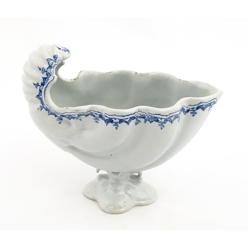 121 - A Continental pedestal blue and white spoon warmer of nautilus shell form. Approx. 7 3/4