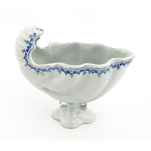 121 - A Continental pedestal blue and white spoon warmer of nautilus shell form. Approx. 7 3/4