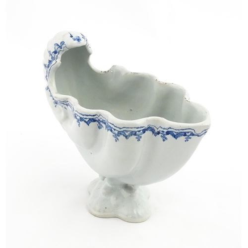 121 - A Continental pedestal blue and white spoon warmer of nautilus shell form. Approx. 7 3/4