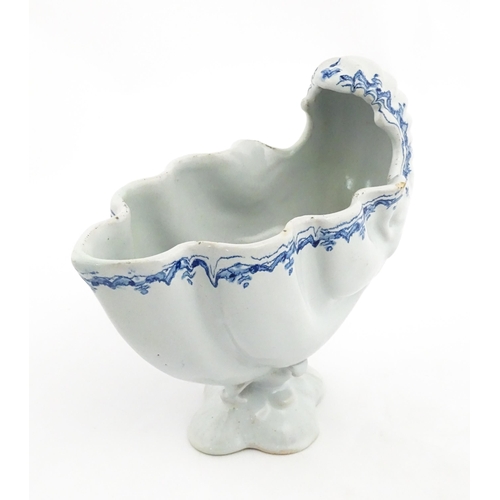 121 - A Continental pedestal blue and white spoon warmer of nautilus shell form. Approx. 7 3/4