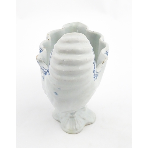 121 - A Continental pedestal blue and white spoon warmer of nautilus shell form. Approx. 7 3/4