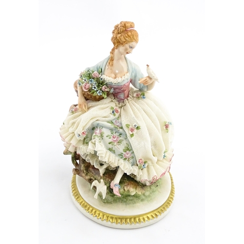 125 - An Italian Capodimonte figure depicting a seated lady with birds, by Giuseppe Cappe. With hand paint... 