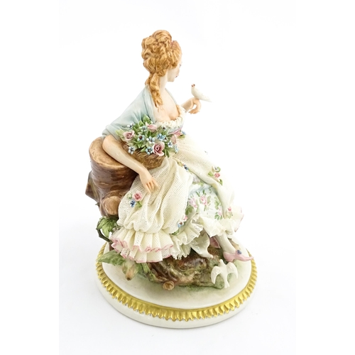 125 - An Italian Capodimonte figure depicting a seated lady with birds, by Giuseppe Cappe. With hand paint... 