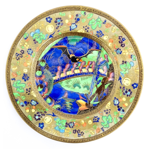 132 - A Wedgwood Fairyland lustre plate decorated in the Imps on a Bridge - Roc Centre pattern, designed b... 