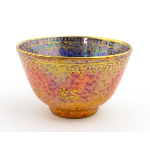 137 - A Wedgwood Fairyland lustre tea bowl decorated with stylised Character marks to exterior and an anim... 