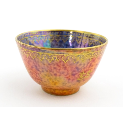 137 - A Wedgwood Fairyland lustre tea bowl decorated with stylised Character marks to exterior and an anim... 