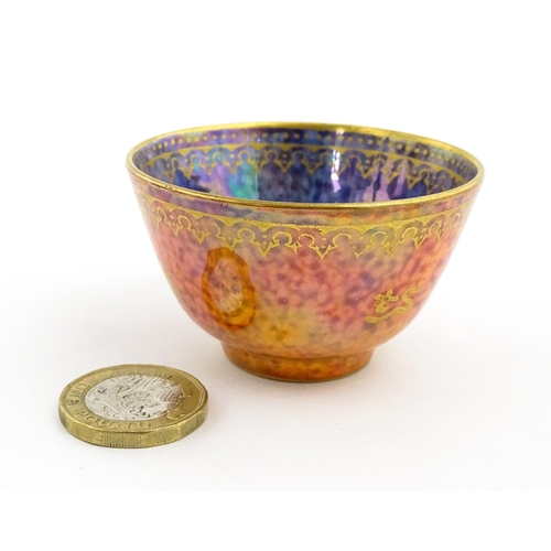 137 - A Wedgwood Fairyland lustre tea bowl decorated with stylised Character marks to exterior and an anim... 