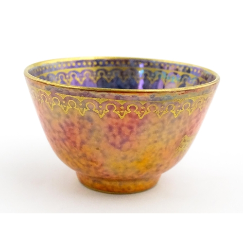 137 - A Wedgwood Fairyland lustre tea bowl decorated with stylised Character marks to exterior and an anim... 