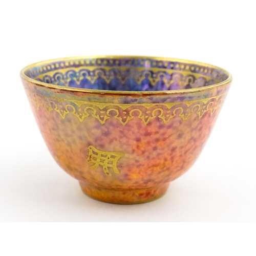 137 - A Wedgwood Fairyland lustre tea bowl decorated with stylised Character marks to exterior and an anim... 