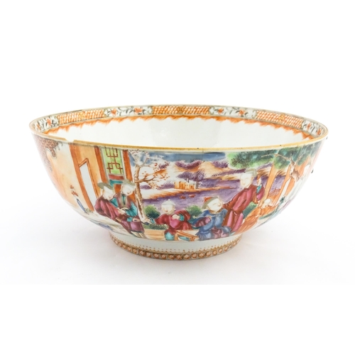 17 - A Chinese Export punch bowl decorated in the Mandarin palette with figures in a landscape with river... 