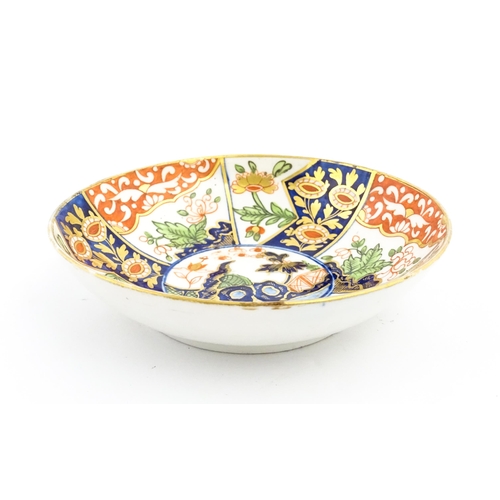 99 - A Derby coffee cup and saucer decorated in the Imari palette with flowers and foliage. Both pieces m... 