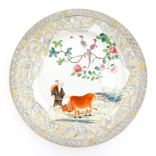 23 - A Chinese export plate decorated with a figure, ox, birds and flowers in a landscape with grisaille ... 