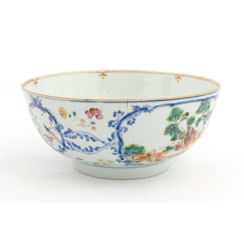 3 - A Chinese Export famille rose punch bowl decorated with two figures and a dog, birds, flowers and fo... 