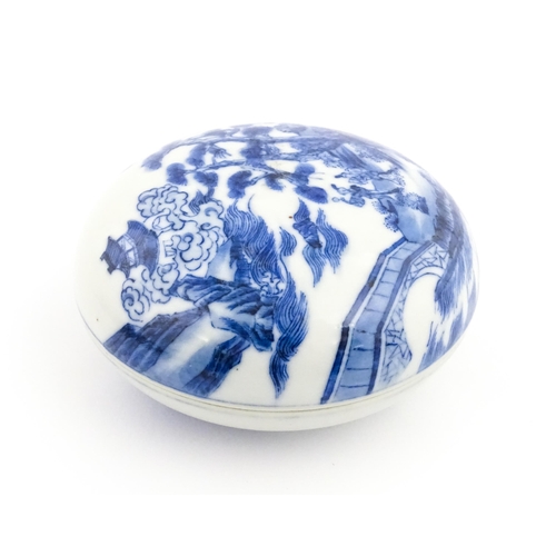 33 - A Chinese blue and white ink box of circular form decorated with figures in a landscape scene with a... 