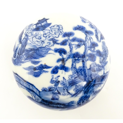 33 - A Chinese blue and white ink box of circular form decorated with figures in a landscape scene with a... 