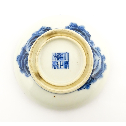 33 - A Chinese blue and white ink box of circular form decorated with figures in a landscape scene with a... 