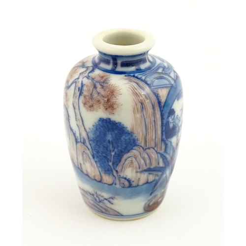 36 - A small Chinese blue and white vase depicting figures in a landscape. Approx. 2 3/4