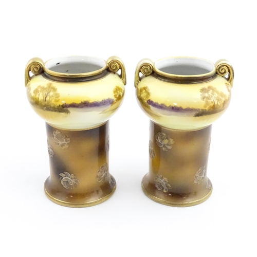 46 - A pair of Noritake vases with scrolling handles, having hand painted decoration depicting a bridge o... 