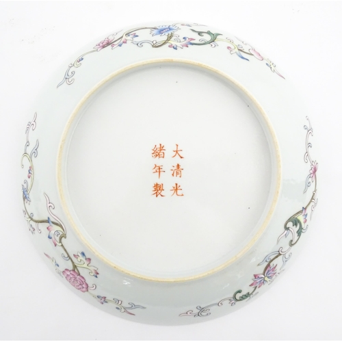 49 - A Chinese famille rose plate decorated with three dragons and a flaming pearl of wisdom. The reverse... 